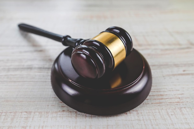 Wooden judge's gavel and soundboard on a light wooden background