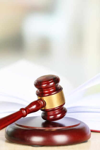 Wooden judges gavel lying on law book close up