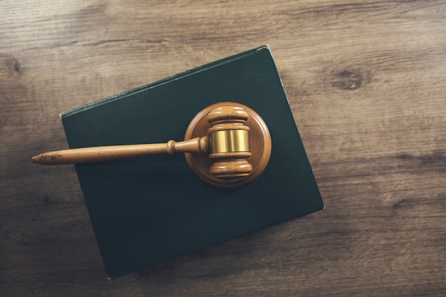 Photo wooden judges gavel lying on a law book