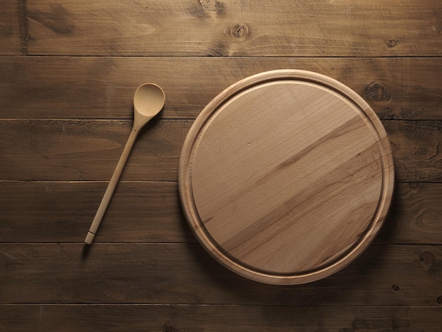 Wooden kitchen board and spoon on the table