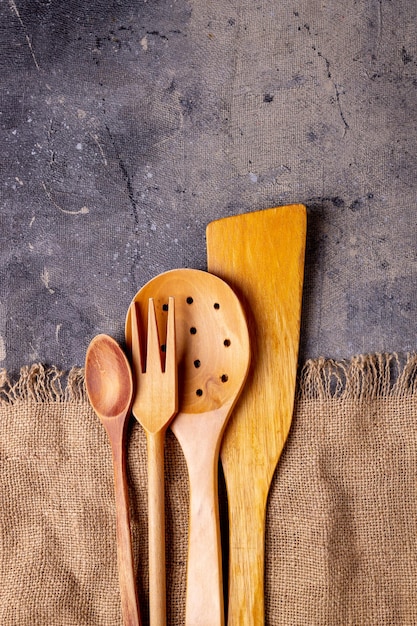 Wooden kitchen tools lie on a rough canvas napkin with a fringe