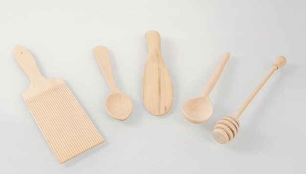 Wooden kitchen utensilsVarious wooden cooking tools arranged in a semicircle on a light background