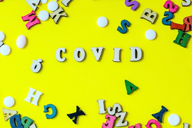 The wooden letters are the word covid. Concept on the theme of flu, virus.