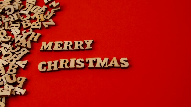 Wooden letters on a deep red background written in English quotMerry Christmasquot