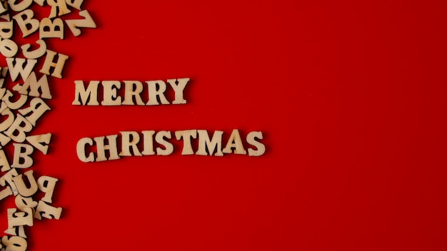 Wooden letters on a deep red background written in English quotMerry Christmasquot