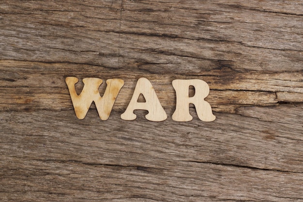 Wooden letters folded into the word war on a wooden table