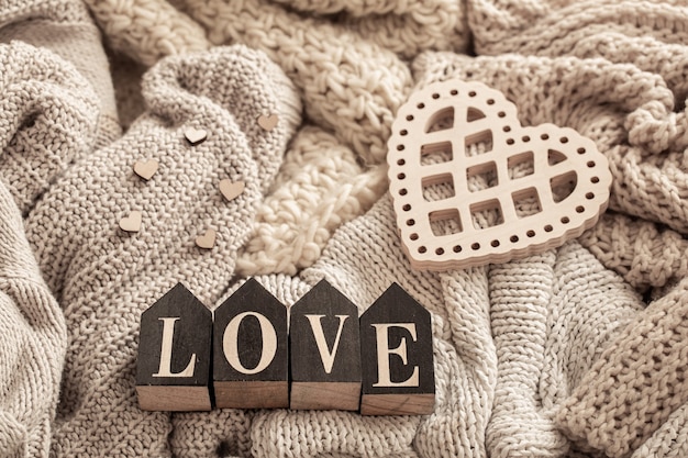 Photo wooden letters make up the word love on a background of cozy knitted items. valentine's day holiday concept.