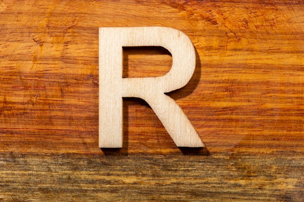 Wooden letters R on wooden background top view