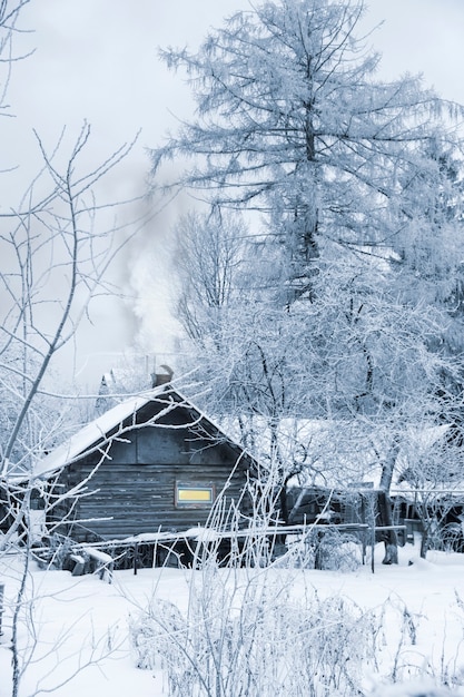 Wooden log old bath beside winter snowy forest