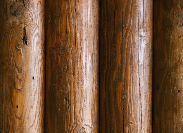 Wooden logs walls of the house Texture of brown logs Rustic background Vertically arranged boards