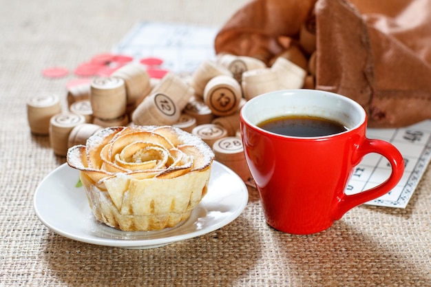 Wooden lotto barrels in brown pouch and game cards for a game in lotto with cup of coffee