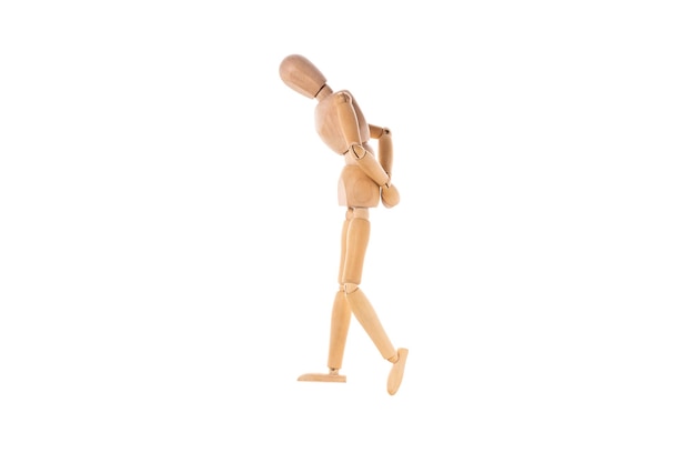 Wooden man walks sad with his hands behind his back isolated on white background High quality photo