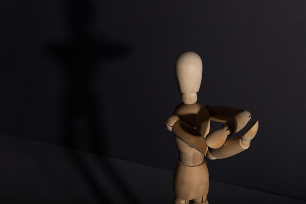 Wooden mannequin shows obscene gesture fuck off with hands on gray background protest riot agression concept copy space