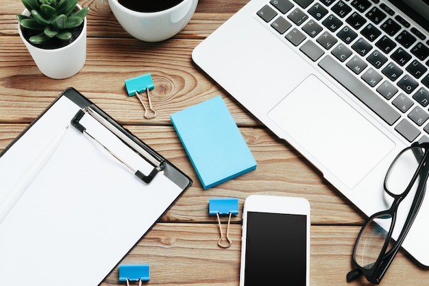 Photo wooden office desk table and equipment for working with black coffee in angle view