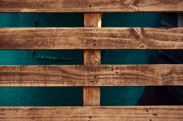 Photo a wooden pallet stands leaning against a green iron structure.