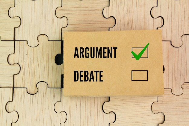 wooden and paper puzzle with the word Debates or argument select argument