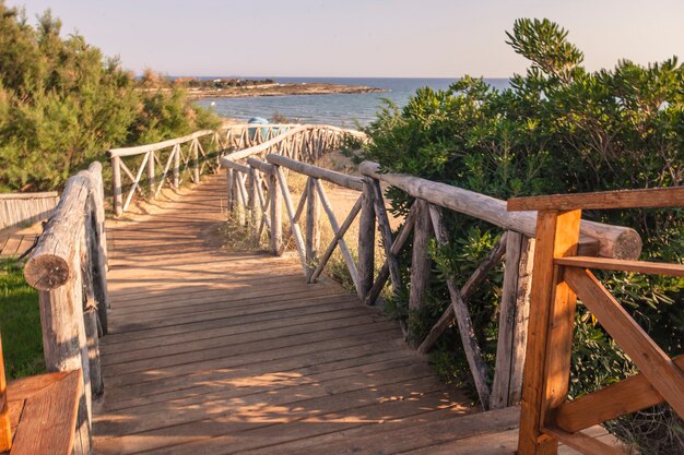 Photo wooden path leading to the beach in modica's beach in sicily