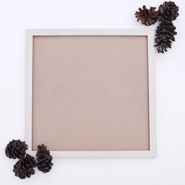 Wooden photo frame mockup with pines on white background.