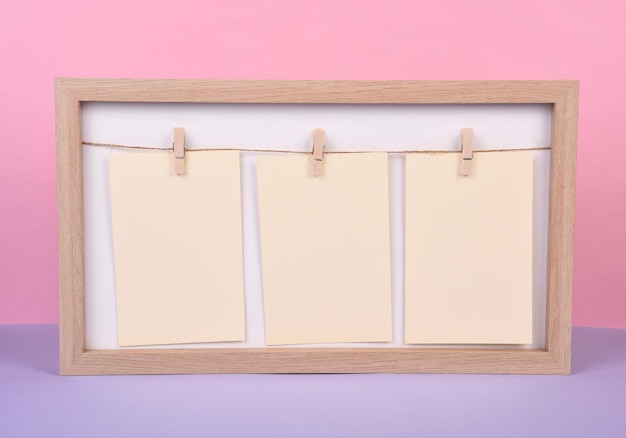 Wooden photo frame with three blank sheets of  paper on a string where you can write text