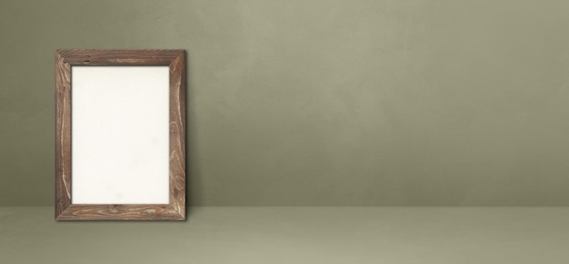 Wooden picture frame leaning on a grey wall. Blank mockup template. Horizontal banner