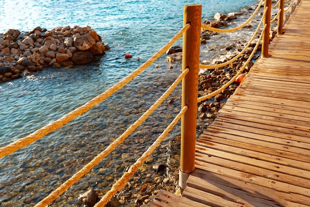 Photo a wooden pier on the beach in resort hotel