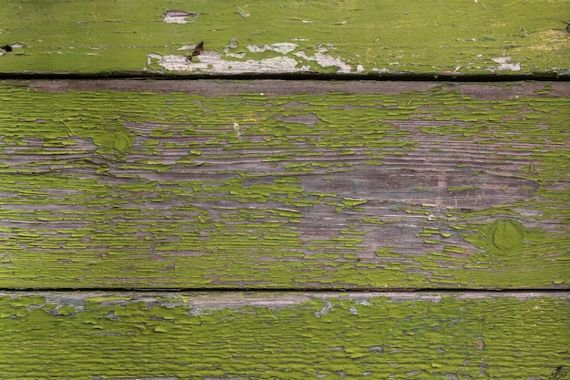 Wooden planks with old peeling green paint