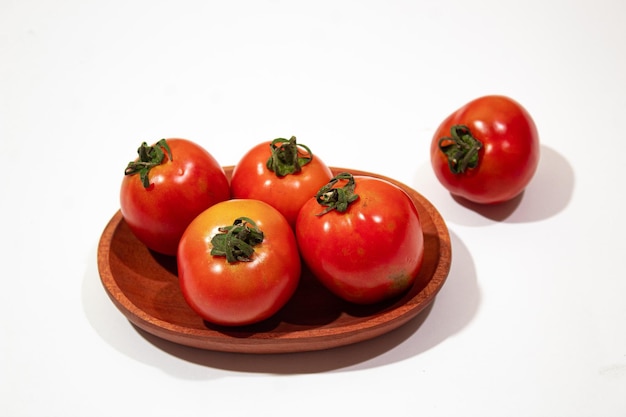 wooden plate of red tomatoes