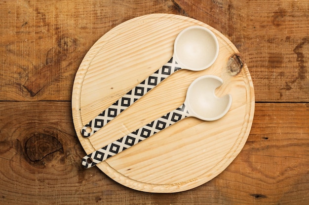 Wooden plate and serving spoons on a wooden table