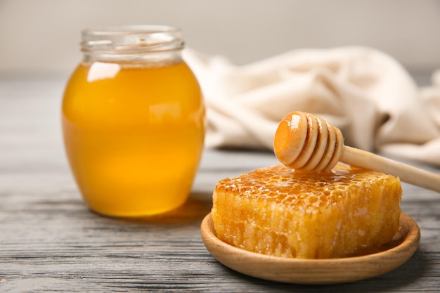 Wooden plate with fresh honeycomb on table closeup