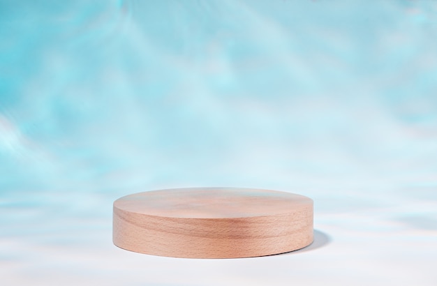 Wooden podium or product stand by swimming pool with reflection of sunlight from water