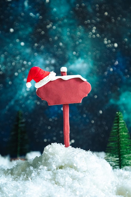 Wooden pointer and Santa's hat on the background of the night starry sky