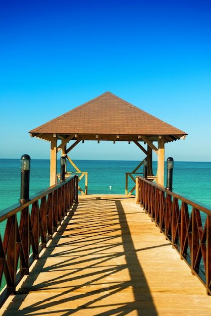 Wooden pontoon. Dock with canopy stretching into the sea