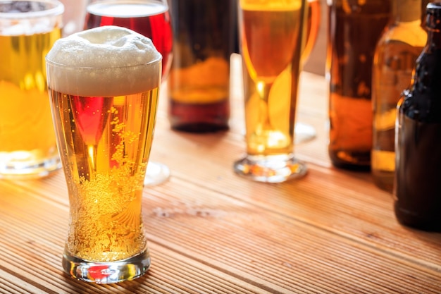 A wooden pub counter focus on a full frosty glass of beer