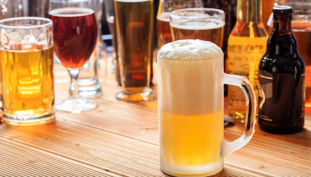 A wooden pub counter focus on a full frosty mug of beer