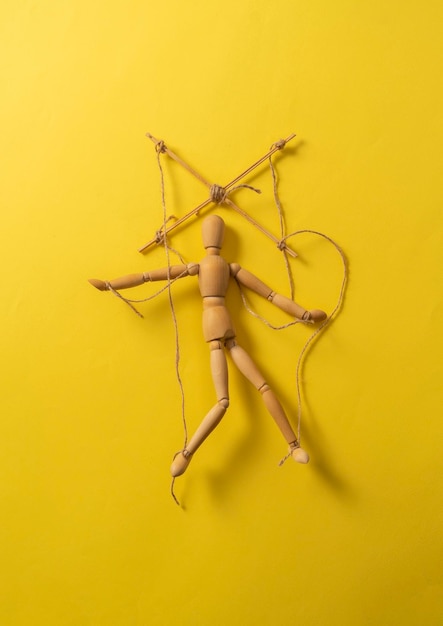 A wooden puppet marionette doll with threads isolated flat lay