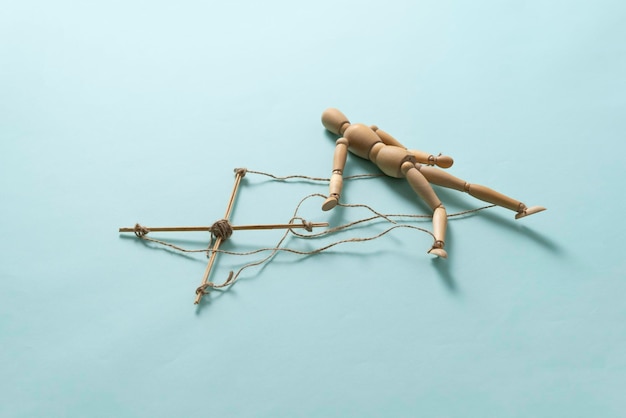 A wooden puppet marionette doll with threads isolated flat lay