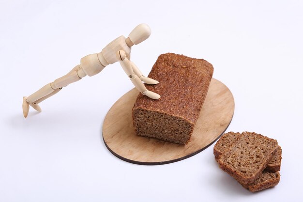 Wooden puppet pushups from whole grain rye bread on white background Fitness concept