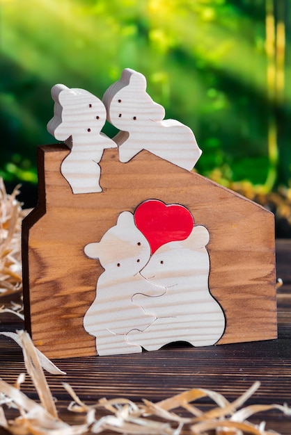 Wooden puzzle in the form of a family of handmade bears on the background of the forest