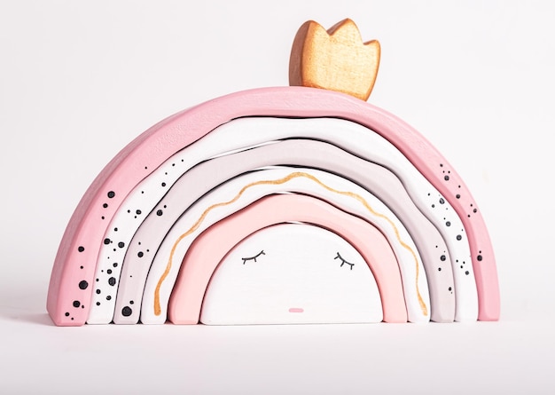 Wooden rainbow stacking toy from arcs like princess Children sleep concept Game for toddler in tender pink pastel colors