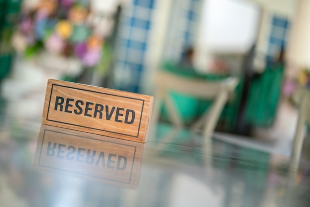 A wooden reserved sign that placed on the dining table at the luxury restaurant for booking the seat