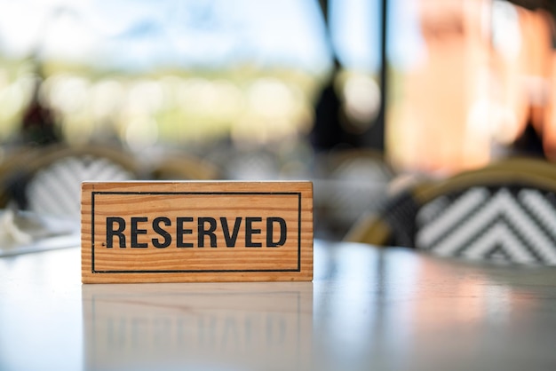 A wooden reserved sign that placed on the dining table at the luxury restaurant for booking the seat