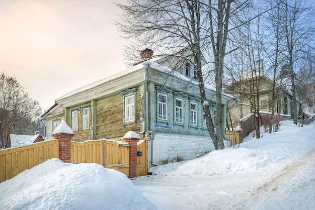 Wooden residential building on a mountainside in Plyos in the light of a winter day under a blue sky