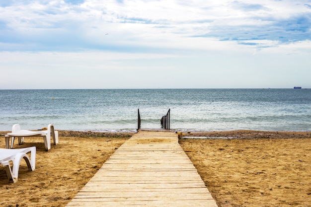 Photo wooden road on the beach to the sea