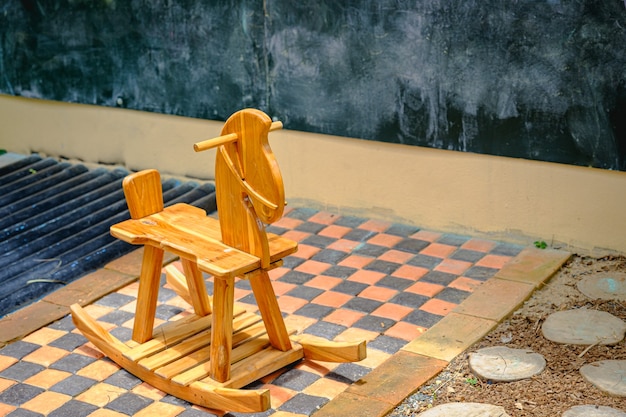 Wooden rocking horse from a childs playroom sitting in the sunlight