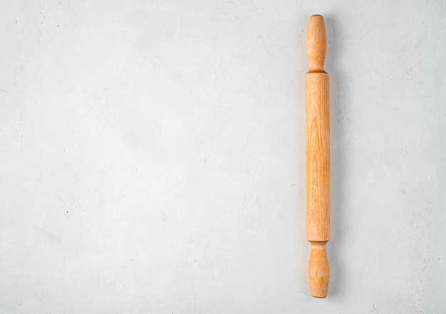 Wooden rolling pin on a gray background. Culinary background. Top view, copy space.