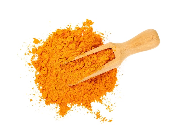 Wooden scoop full of yellow turmeric powder