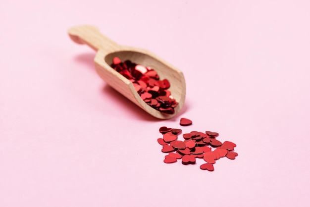 Wooden Scoop with Red Heart Confetti Pink Background Horizontal Veltntine Day