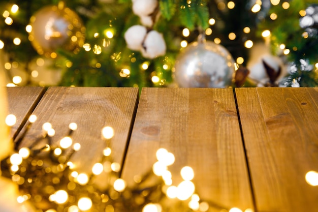 Wooden shelf against background of New Year glowing garland on Christmas tree