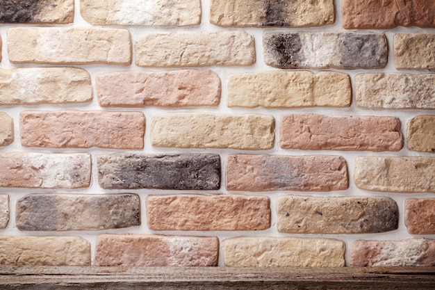 Wooden shelf in front of brick wall