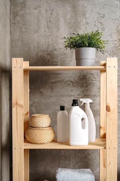 Photo wooden shelf with liquid detergents containers in a bathroom